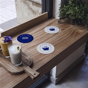 木质桌面上的3个蓝色杯垫隔热垫贴图样机