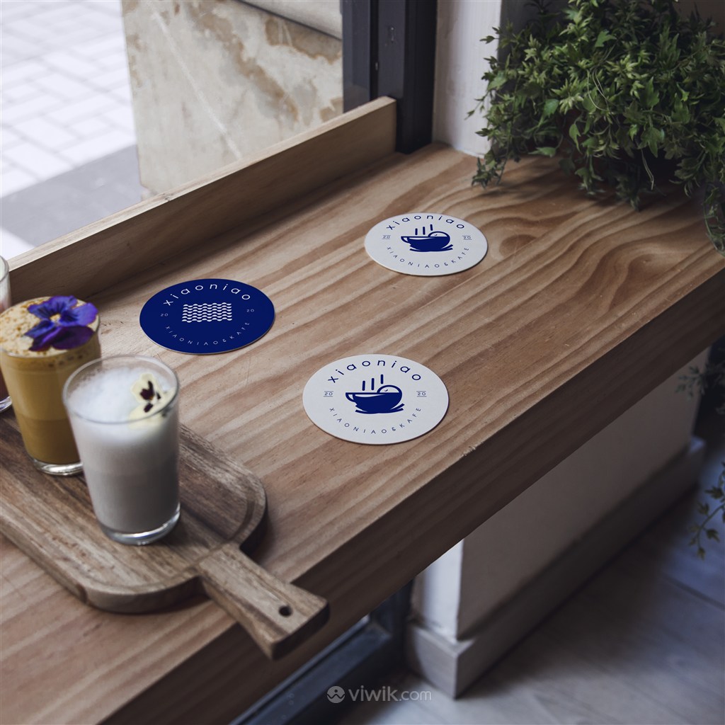 木质桌面上的3个蓝色杯垫隔热垫贴图样机