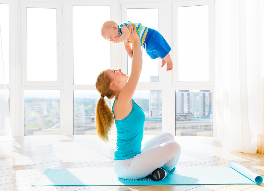 高清练瑜伽的女性举起自己的宝贝孩子图片.jpg