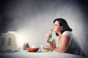 吃着美食用老旧电视机看电视的肥胖女人图片