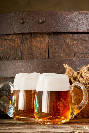 木桶背景装满啤酒的玻璃杯图片
