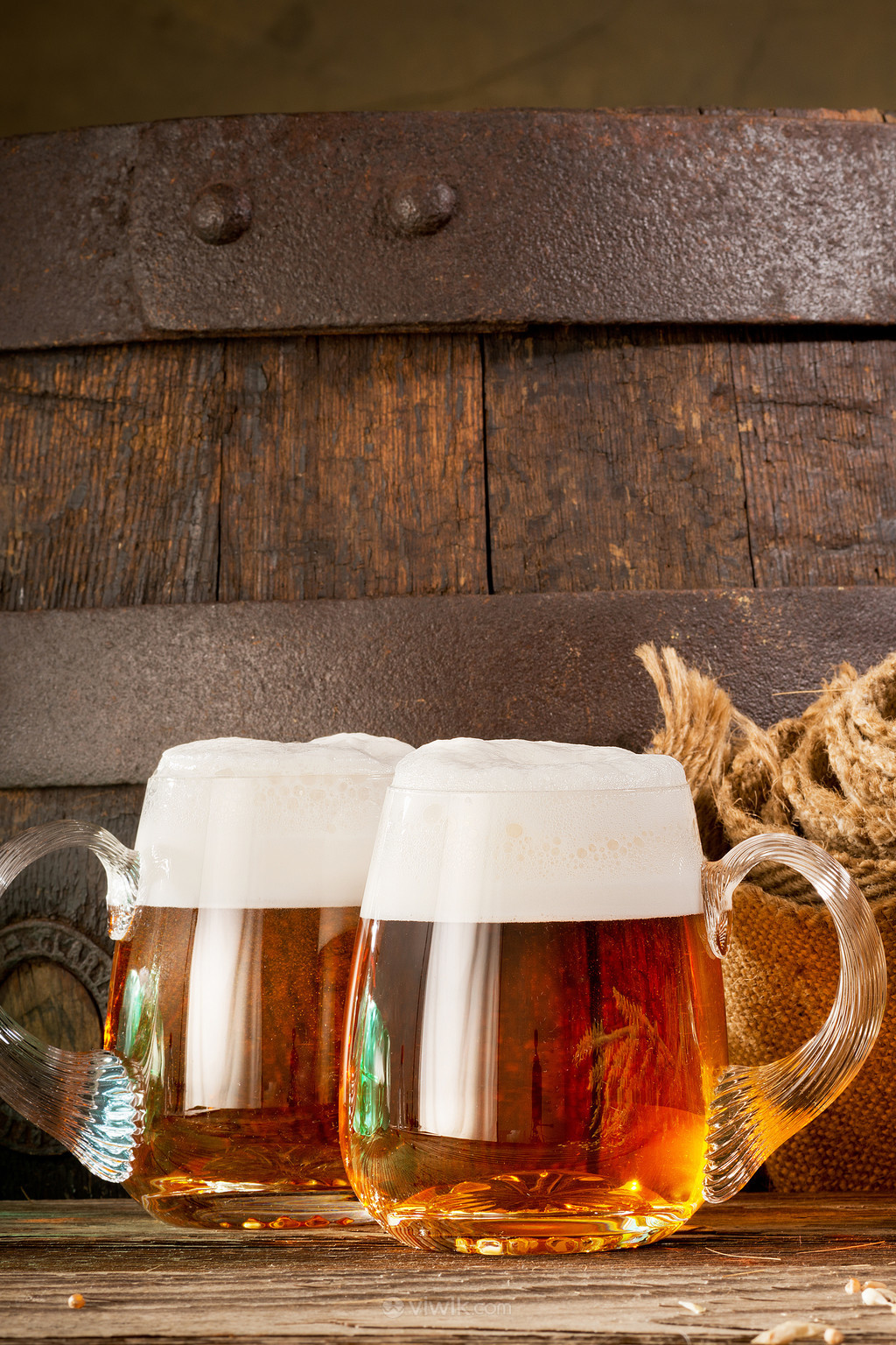 木桶背景装满啤酒的玻璃杯图片