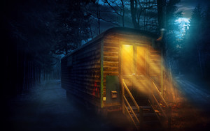 夜晚森林里的小木屋还亮着温暖的灯光图片