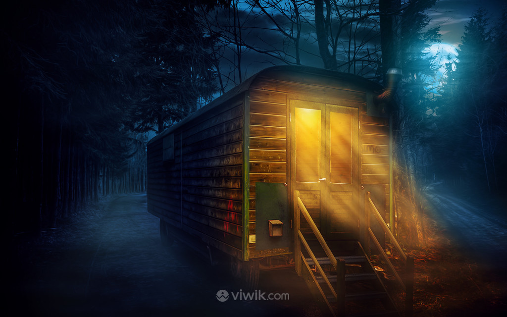 夜晚森林里的小木屋还亮着温暖的灯光图片