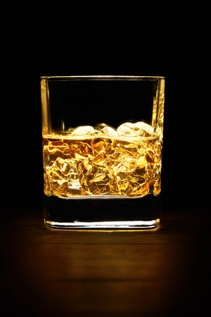 黑色背景一杯加了冰块的威士忌图片
