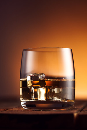 桌面上一杯加了冰块的威士忌图片