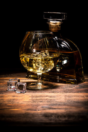 一瓶威士忌和一杯加了冰块的酒图片