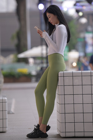 国产亚洲日产街拍玩手机的紧身裤美女图片