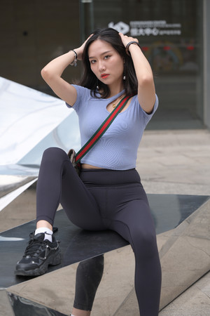 亚洲激情街拍撩头发的紧身裤美女图片