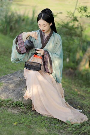 汉服艺术照写真坐在石头上自斟自饮的古装美女图片
