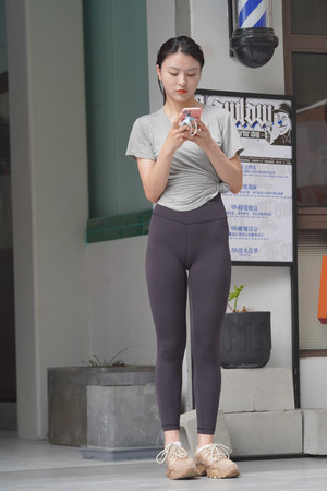 亚洲精品久久安然街拍玩手机的瑜伽裤美女图片