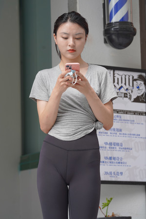 国产手机精品一区街拍玩手机的瑜伽裤美女图片
