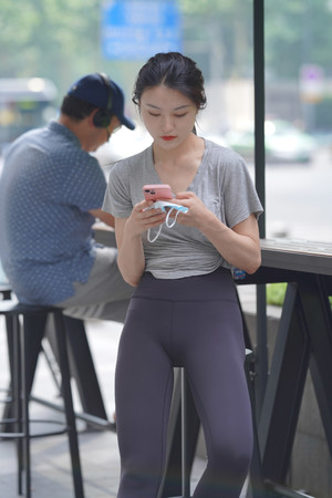 久久国产精品街拍坐在高脚凳上玩手机的瑜伽裤美女图片